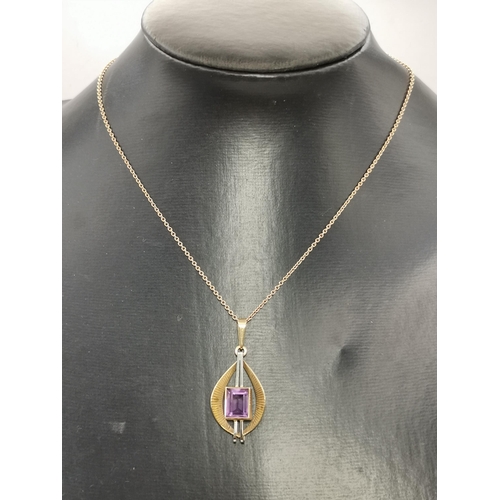 444A - A 9 carat gold gem-stone pendant, set with a rectangular purple stone to twin vertical white gold ba... 