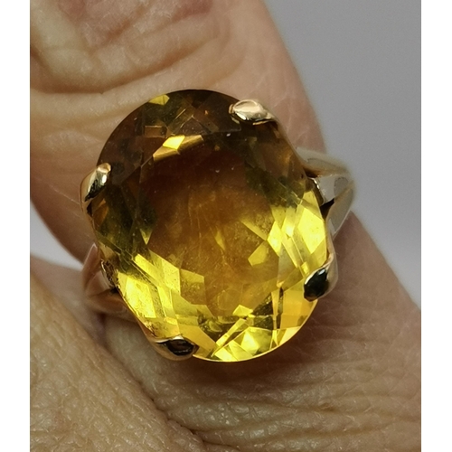 445A - An 18 carat gold citrine ring, the oval stone claw-mounted to trifurcated openwork shoulders in a ra... 