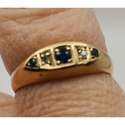 458 - An 18 carat gold five-stone ring, the broad navette-shaped top set with three graduated round blue s... 