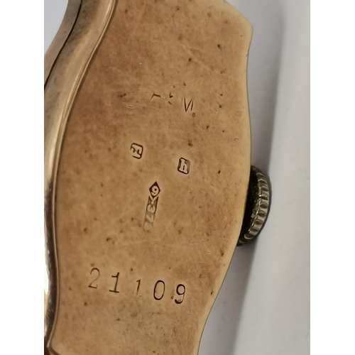 484 - A lady's Art Deco 9 carat gold wristwatch, the white oval dial with a gilded centre, black Arabic nu... 