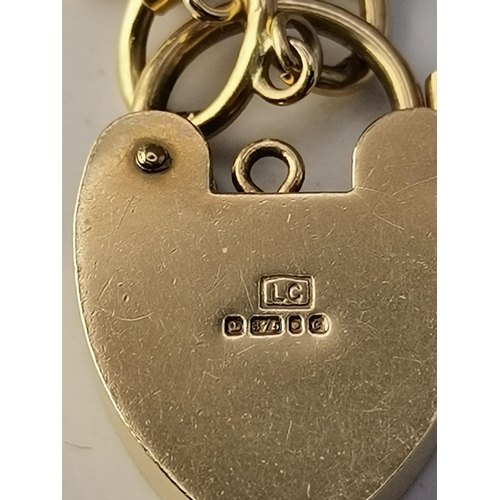 524A - A 9 carat gold gate-link bracelet with heart padlock clasp, the lock with engraved decoration, hallm... 