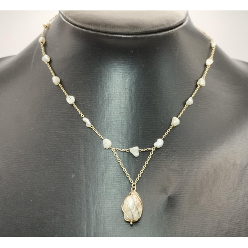 527 - A 9 carat gold-mounted baroque pearl necklace, the fine trace chain spaced with twenty-one small pea... 