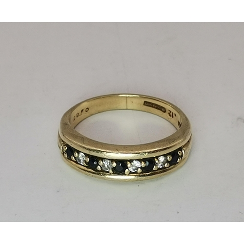 528 - A 9 carat gold three stone ring, the central blue round stone flanked by two round white stones, cla... 