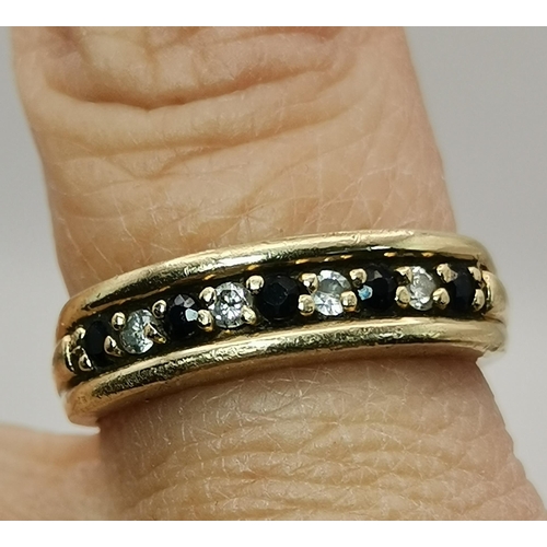 528 - A 9 carat gold three stone ring, the central blue round stone flanked by two round white stones, cla... 