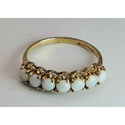 529 - A 9 carat opal half-hoop ring, claw-set with seven stones to a pierced and open-backed gallery setti... 