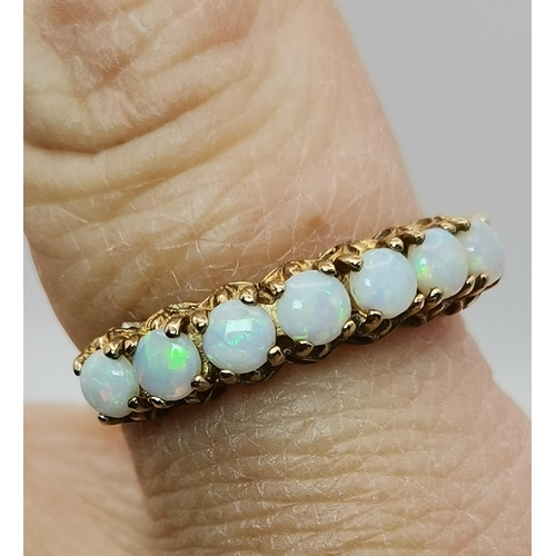 529 - A 9 carat opal half-hoop ring, claw-set with seven stones to a pierced and open-backed gallery setti... 
