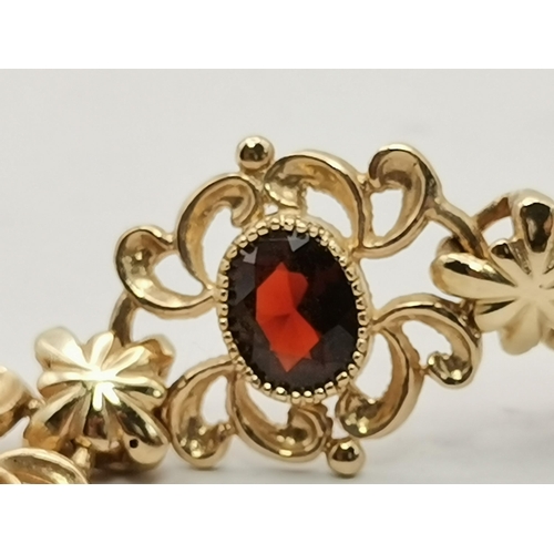529A - A 9 carat gold and eight stone garnet fancy link bracelet, the oval stones set to ornate scrolling l... 