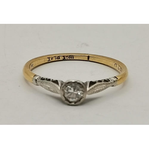 534A - An 18 carat gold and platinum solitaire ring, the single circular white stone to feather-decorated p... 