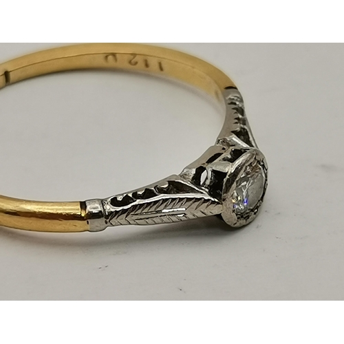 534A - An 18 carat gold and platinum solitaire ring, the single circular white stone to feather-decorated p... 