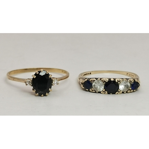 548A - A 9 carat gold five stone ring, with three graduated round blue stones spaced by two round white sto... 