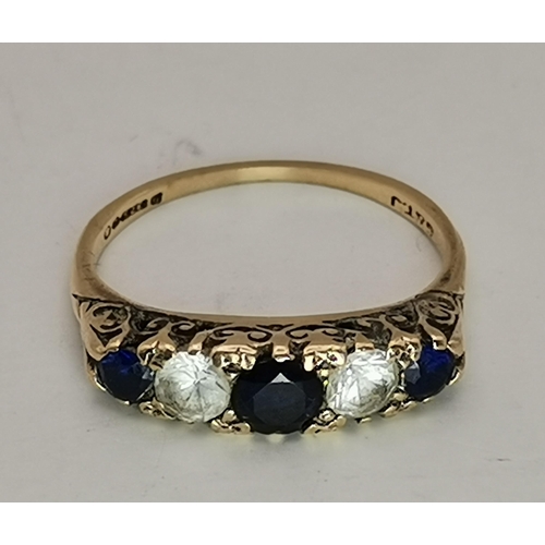 548A - A 9 carat gold five stone ring, with three graduated round blue stones spaced by two round white sto... 