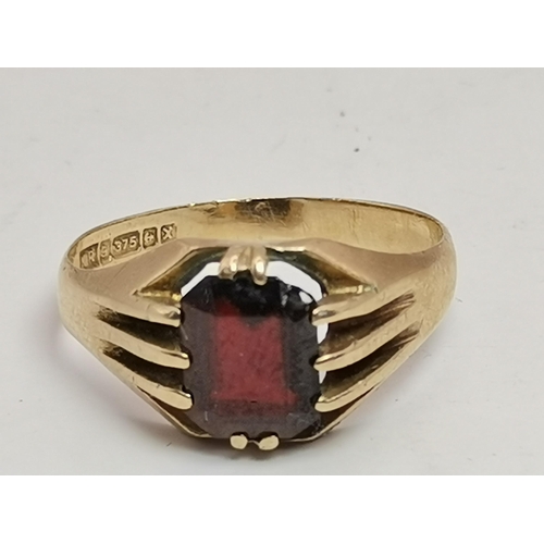 559A - Three 9 carat gold garnet solitaire rings, each with a claw-mounted stone, two rectangular and one o... 