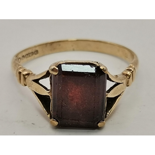 559A - Three 9 carat gold garnet solitaire rings, each with a claw-mounted stone, two rectangular and one o... 