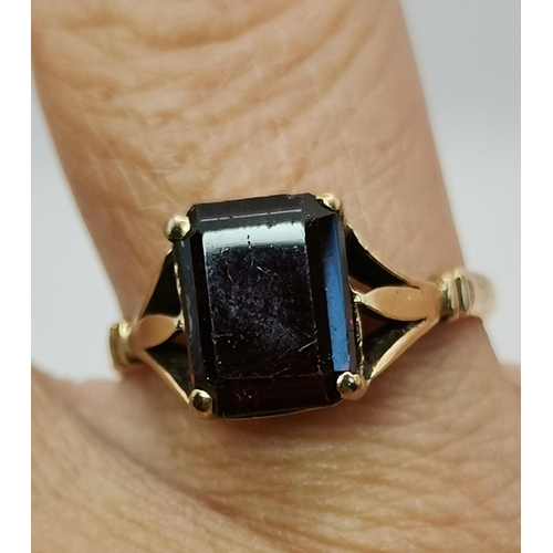 559A - Three 9 carat gold garnet solitaire rings, each with a claw-mounted stone, two rectangular and one o... 