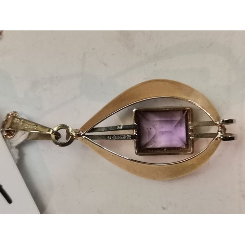 444A - A 9 carat gold gem-stone pendant, set with a rectangular purple stone to twin vertical white gold ba... 