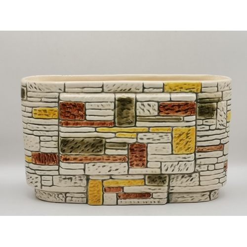 81 - Two pieces of Sylvac pottery, an oval 'brick wall' planter, no. 3653, impressed marks to base; and a... 