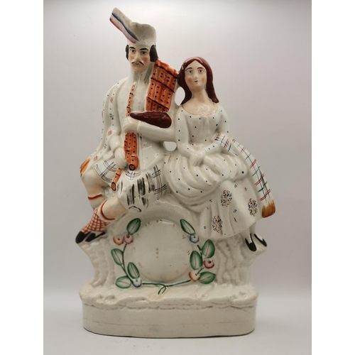 117 - Three Antique Staffordshire figurines - Flatback Highlander Couple with Clock H35cm, Large flatbacke... 