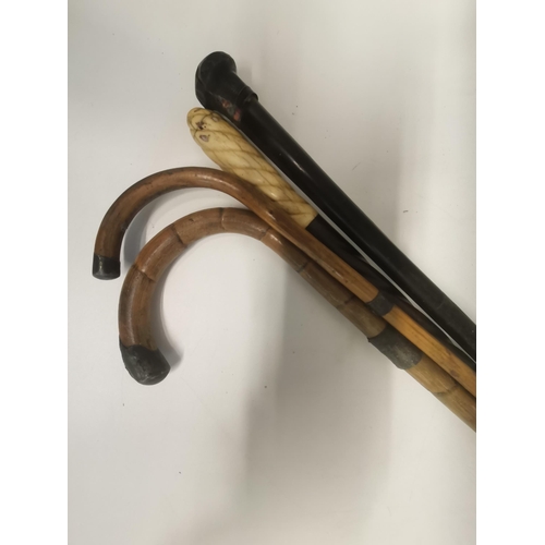 32 - Four assorted walking sticks, comprising three silver-mounted examples, and a bone-handled cane with... 