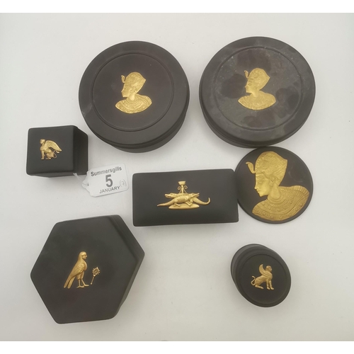 Wedgwood Egyptian Revival: A collection of black basalt Jasperware with gilded decoration, comprising a cameo plaque of Tutankhamun, and assorted boxes and covers with decoration including Sphinx, Horus, and crocodiles. (7) Cameo 7.3cm diameter