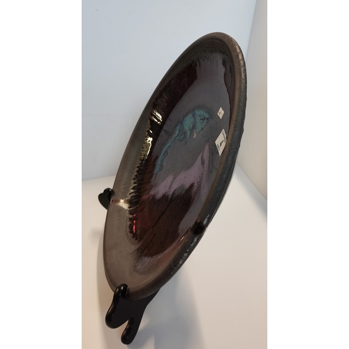 4 - A large New Zealand studio pottery purple-blue glaze charger, c.1990s, with incised signature to bas... 