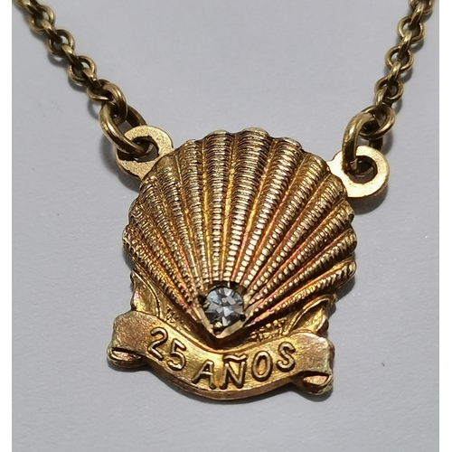 577A - A 14 carat gold tie bar and chain, suspending a scallop shell set with a diamond and '25 AÑOS', hall... 