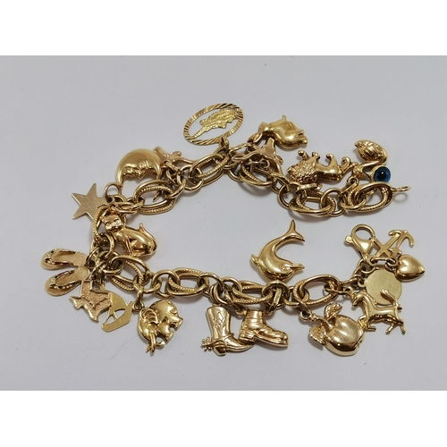 578 - An Italian 18 carat gold fancy-link bracelet hung with an assortment of charms, mostly 18ct, some 14... 