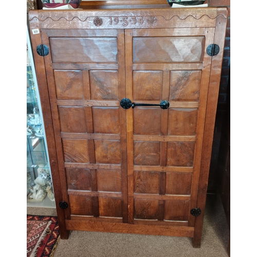 A  very rare early mouseman  oak panelled double wardrobe, beautifully patinated with each wardrobe being inscribed to the top with a Yorkshire rose, a Scottish thistle, the date 1934 and with the initial S 1.7m high x 1.1m x 60cm d The doors have 11 panells with adzed decoration to front and sides. The mouse is carved into the wardrobe on the right hand side..These came from a private estate in Yorkshire
