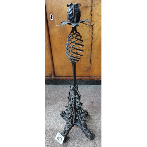 34 - A pair of vintage wrought iron tripod candlesticks with foliate decorated tops and highly twisted ba... 