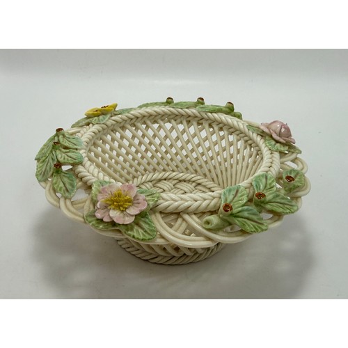 119 - Three pieces of Belleek pottery including String Bag Pot, Scroll Flower ink Irish Vase with gold rim... 