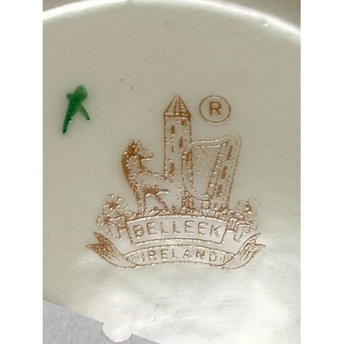 119 - Three pieces of Belleek pottery including String Bag Pot, Scroll Flower ink Irish Vase with gold rim... 
