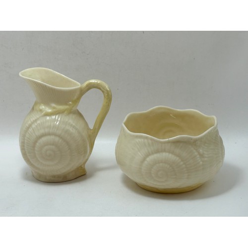  Four pieces of Belleek pottery - Neptune Shell Sugar Bowl and Milk Jug, Sea Shell pink and Cream vas... 