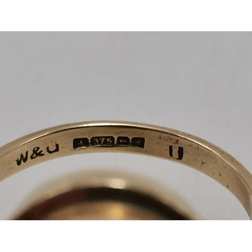  Two 9 carat gold rings, the first collet-set with an oval smoky quartz to pierced scroll shoulders, ... 