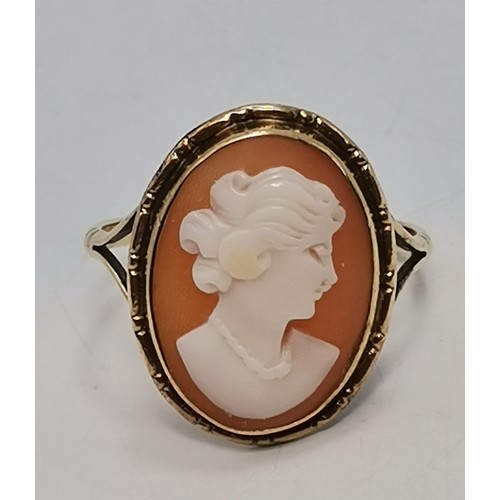  Two 9 carat gold rings, the first collet-set with an oval smoky quartz to pierced scroll shoulders, ... 
