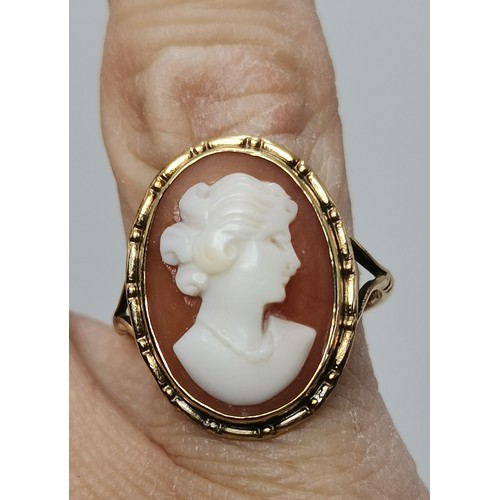  Two 9 carat gold rings, the first collet-set with an oval smoky quartz to pierced scroll shoulders, ... 