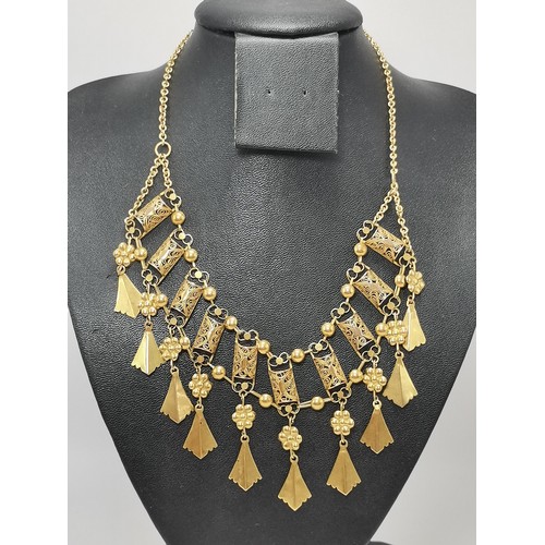 539 - A fancy yellow metal fringe necklace, with ten filigree half-barrel links each hung below with a flo... 