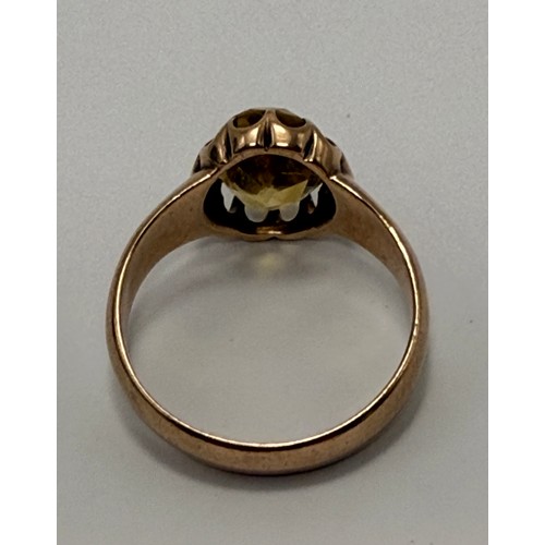  A citrine ring, the oval stone claw-set in a scalloped open-backed setting, to broad tapering should... 