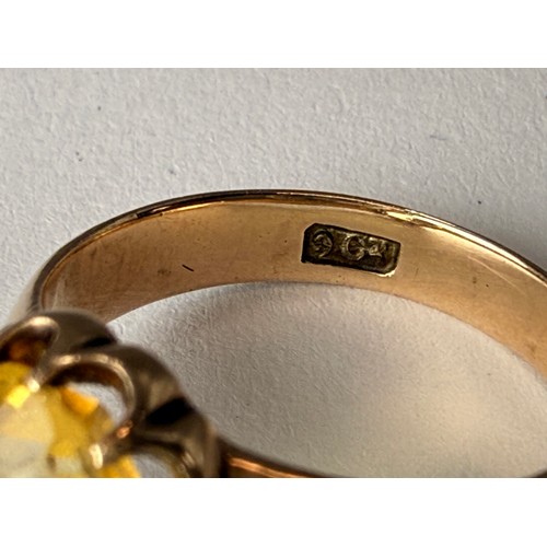  A citrine ring, the oval stone claw-set in a scalloped open-backed setting, to broad tapering should... 