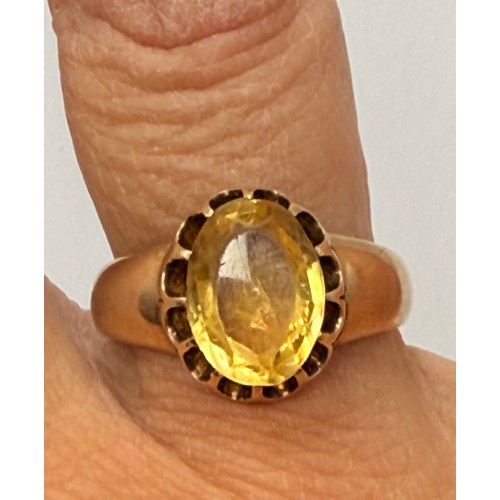  A citrine ring, the oval stone claw-set in a scalloped open-backed setting, to broad tapering should... 
