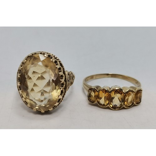 541 - Two 9 carat gold gemstone rings, the first a large oval citrine to a fancy carved c-scroll openwork ... 