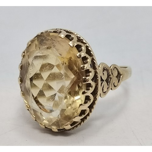 541 - Two 9 carat gold gemstone rings, the first a large oval citrine to a fancy carved c-scroll openwork ... 