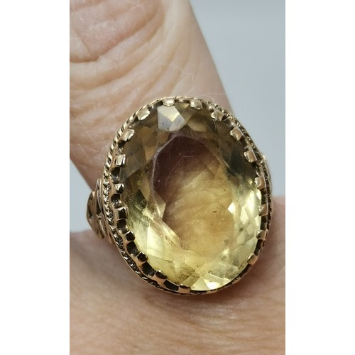 541 - Two 9 carat gold gemstone rings, the first a large oval citrine to a fancy carved c-scroll openwork ... 