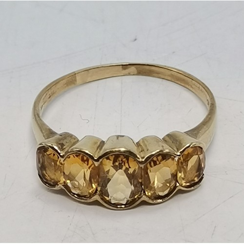 541 - Two 9 carat gold gemstone rings, the first a large oval citrine to a fancy carved c-scroll openwork ... 
