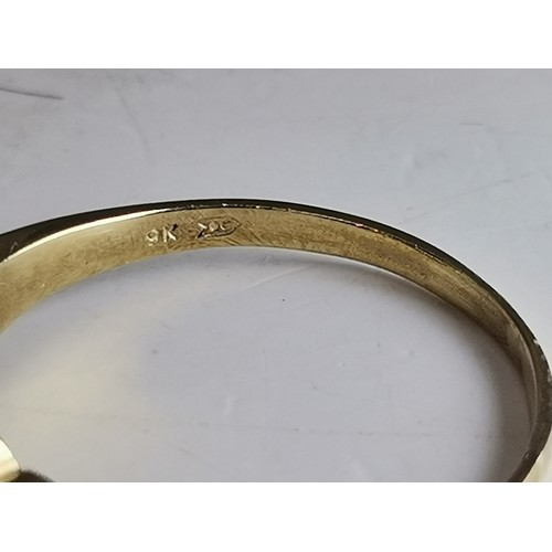 541 - Two 9 carat gold gemstone rings, the first a large oval citrine to a fancy carved c-scroll openwork ... 