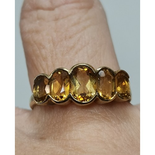 541 - Two 9 carat gold gemstone rings, the first a large oval citrine to a fancy carved c-scroll openwork ... 