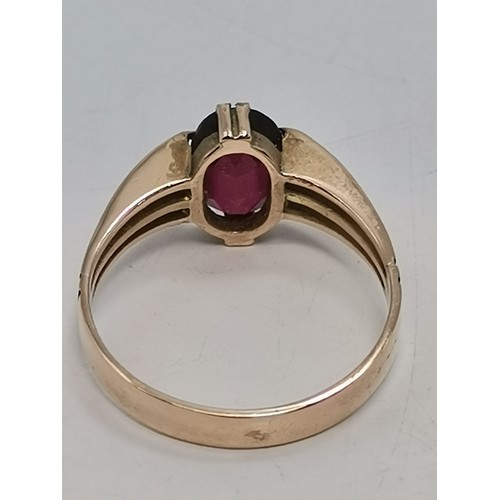  Two 9 carat gold red gemstone rings, the first a rectangular stone with cut corners, claw-mounted in... 