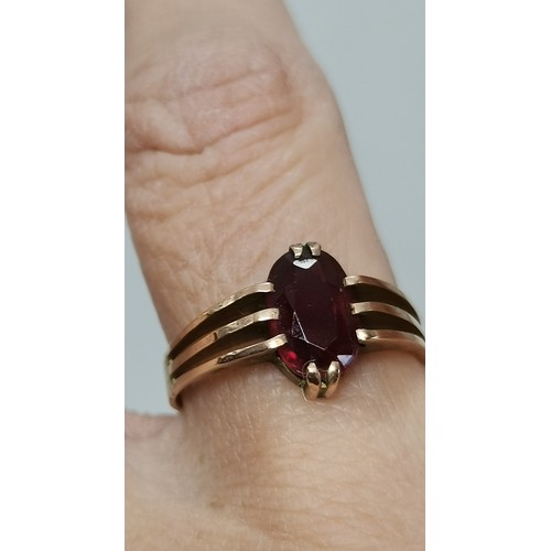  Two 9 carat gold red gemstone rings, the first a rectangular stone with cut corners, claw-mounted in... 