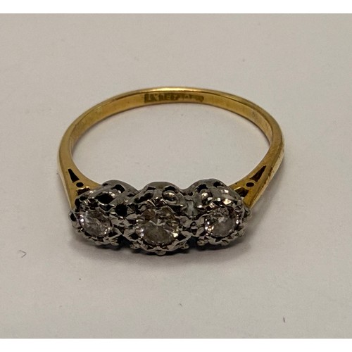 550 - A three-stone ring, set with graduated round white stones, stamped '18CT & PLAT' to shank. Ring size... 