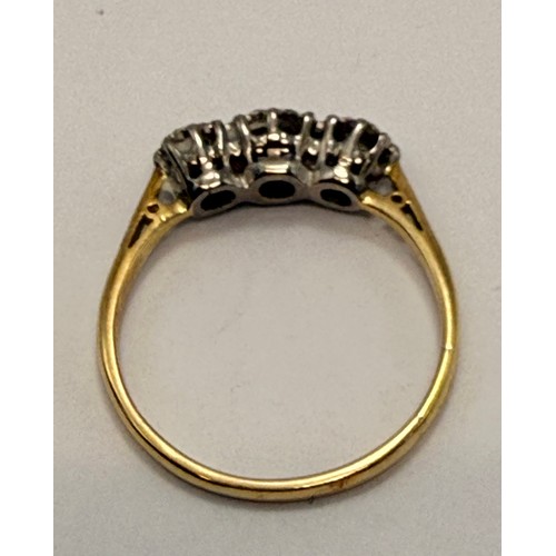 550 - A three-stone ring, set with graduated round white stones, stamped '18CT & PLAT' to shank. Ring size... 