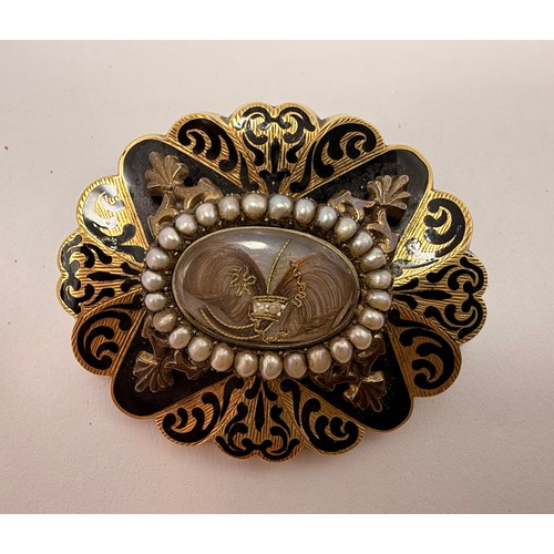  A Victorian enamelled mourning brooch, lobed oval, centred by a glazed hairwork display panel enclos... 