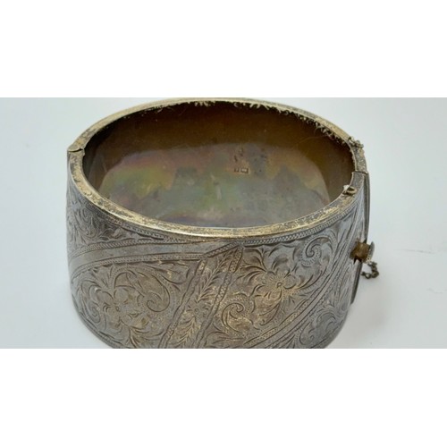 563 - A small group of mixed jewellery including a broad hinge-opening silver bangle by Owen Powell, Birmi... 